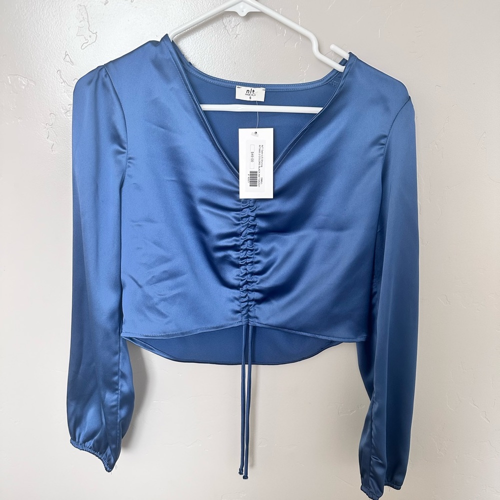 N/t NWT blue shimmer crop long sleeve. Size small. Adjustable tie.